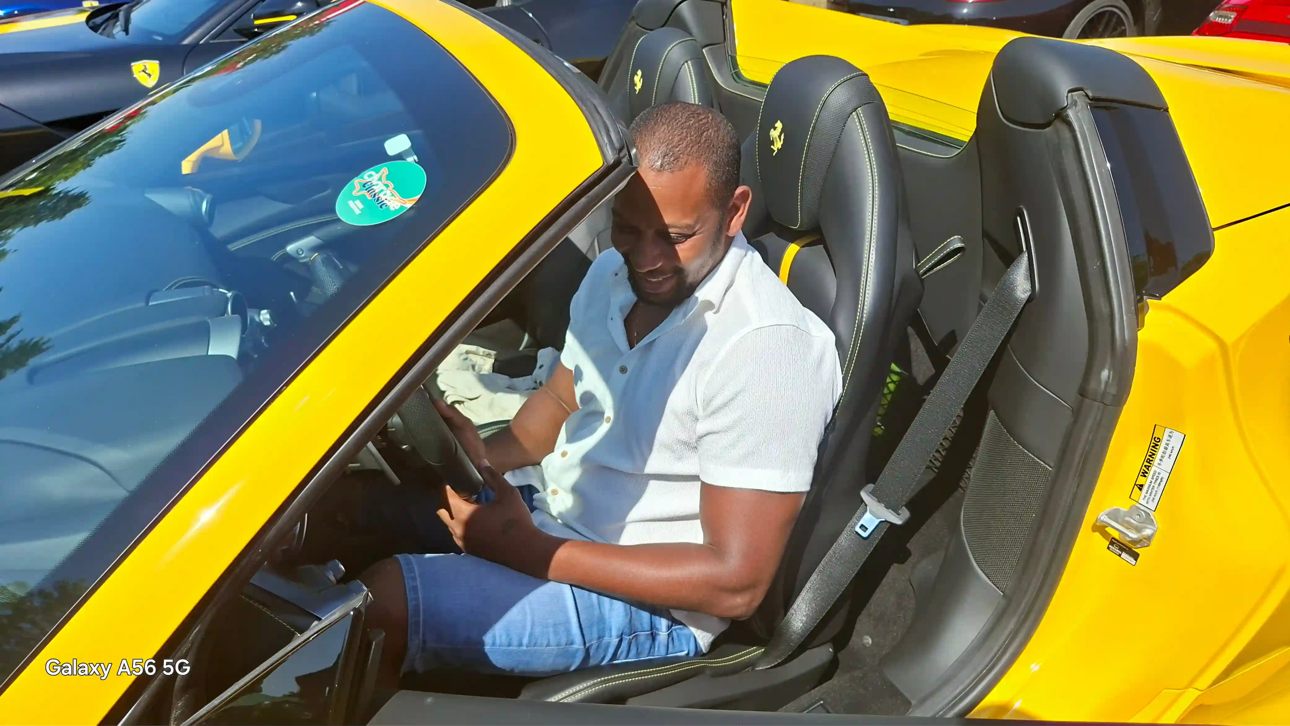Rhony Dalphrase, fondateur de Rhony's Car, au volant d'une Ferrari lors d'un rassemblement de supercars